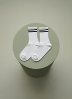 Vita pilates strumpor för träning med halksskydd liggandes på grön cylinder