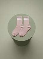 Rosa pilatesstrumpor liggandes på grön cylinder