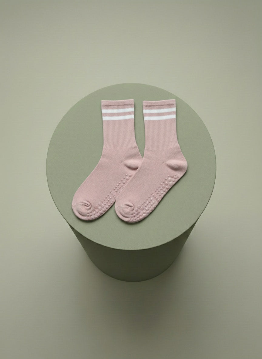 Rosa pilatesstrumpor liggandes på grön cylinder