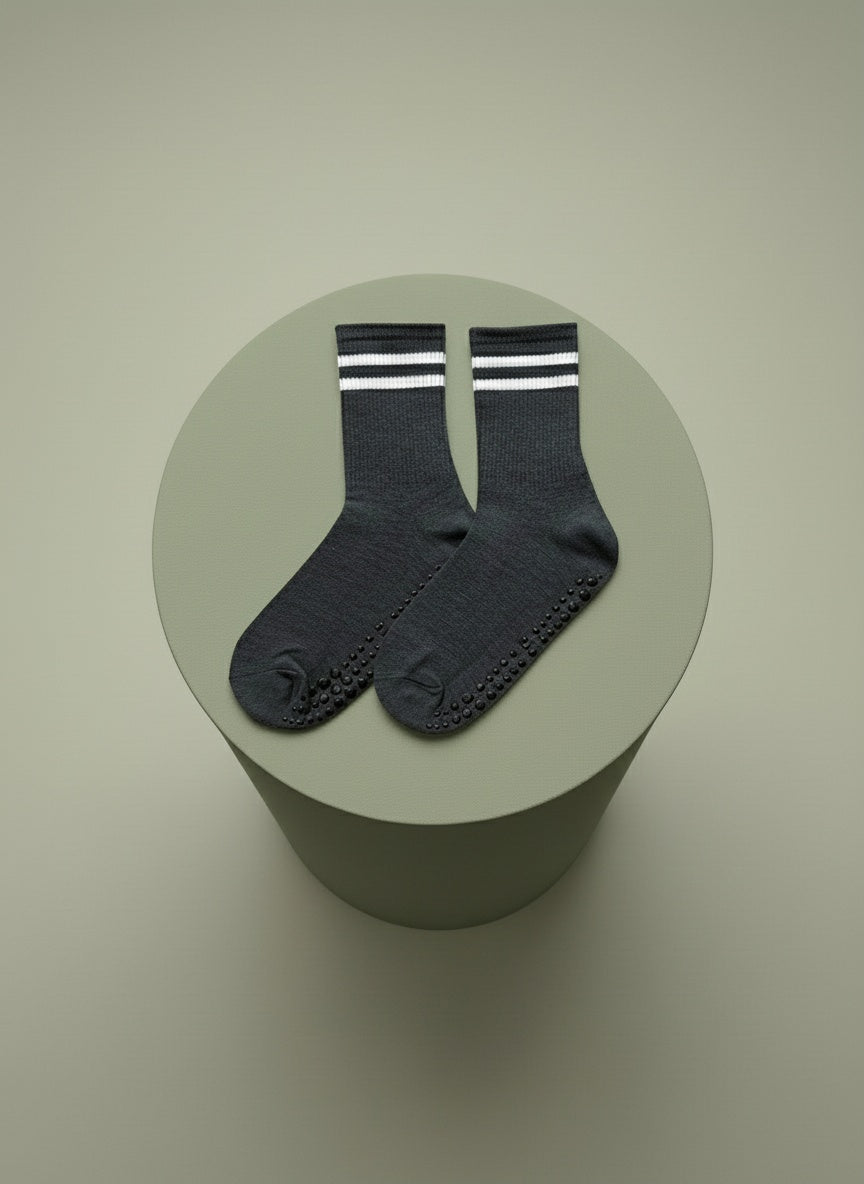 Grå pilates strumpor liggandes på grön cylinder