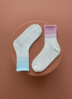 Vita, blåa ch rosa pilates strumpor för kvinnor ligger på röd cylinder år olika håll