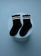 2 par svarta pilatesstrumpor liggandes på blå cylinder