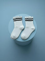 Två pack vita pilatesstrumpor på ljusblå bakgrund