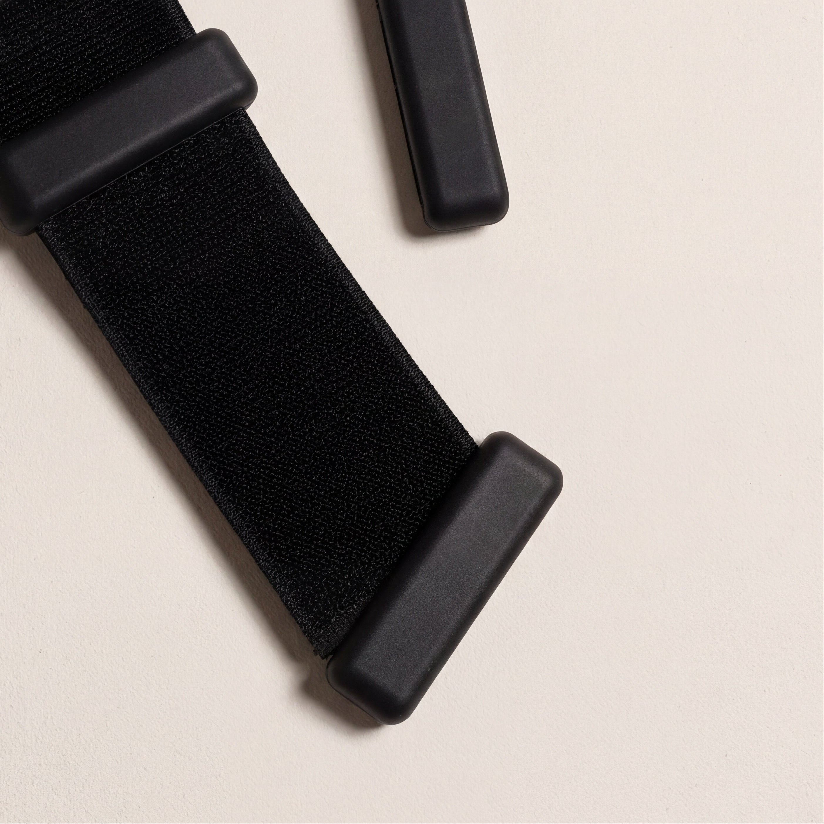 justerbart spänne på ankelvikter för pilates i svrat liggandes på beige golv