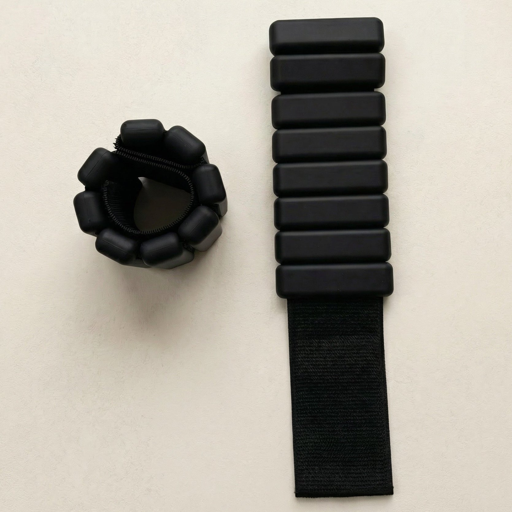 svarta Ankelvikter för pilates liggandes på beige bakgrund