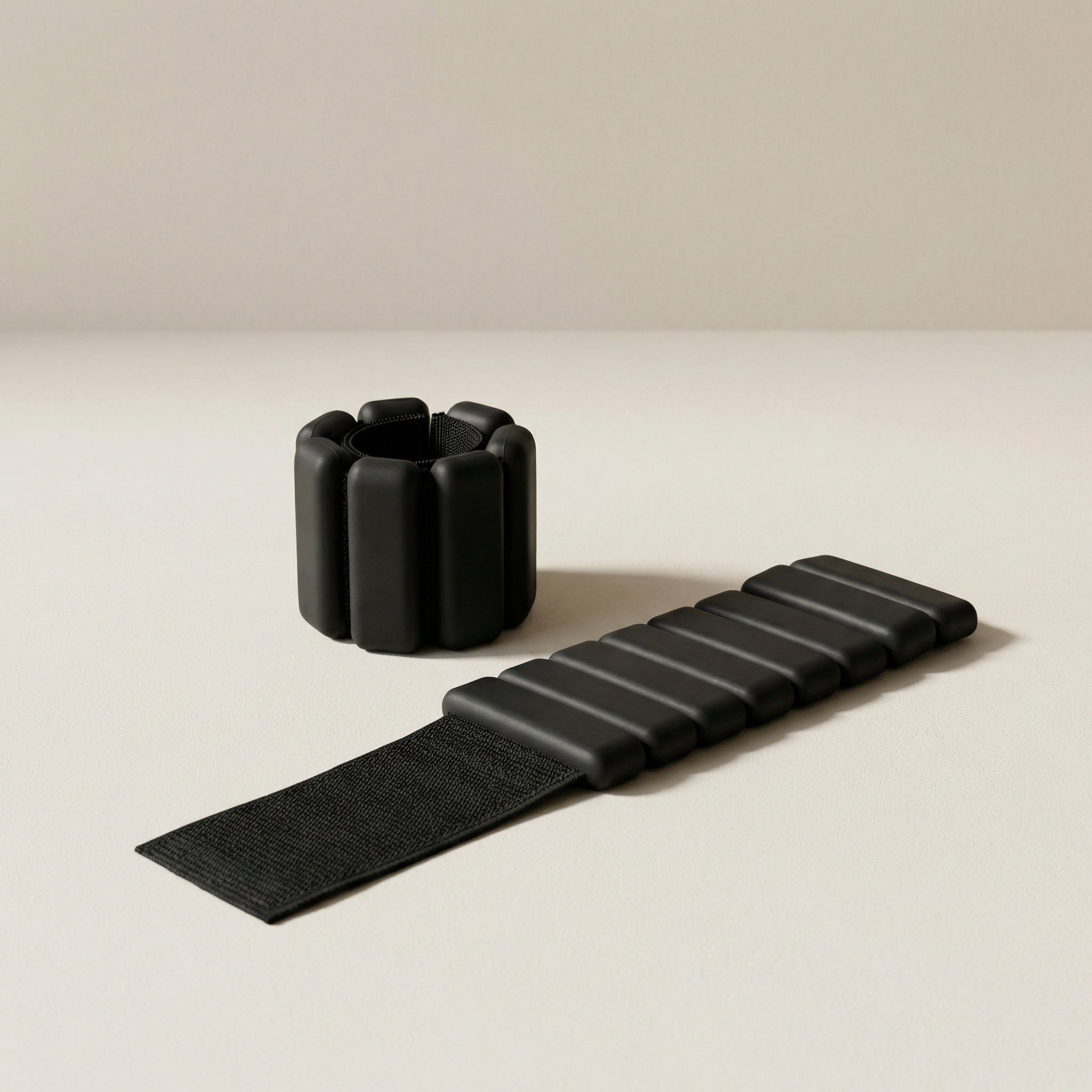 svarta bala bangles pilates handledsvikter liggandes mot beige bakgrund