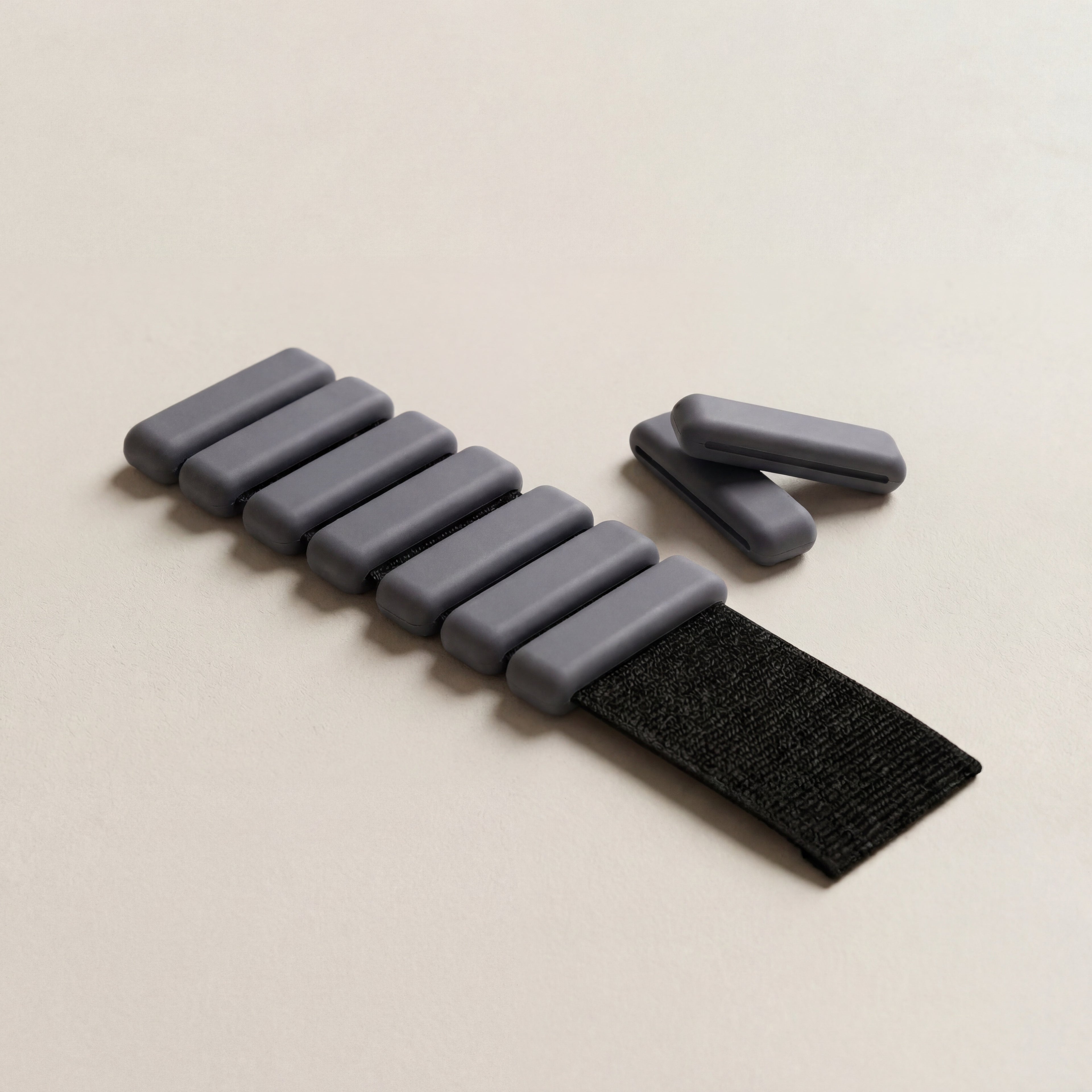 Grå pilates handledsvikter liggandes på vit bakgrund