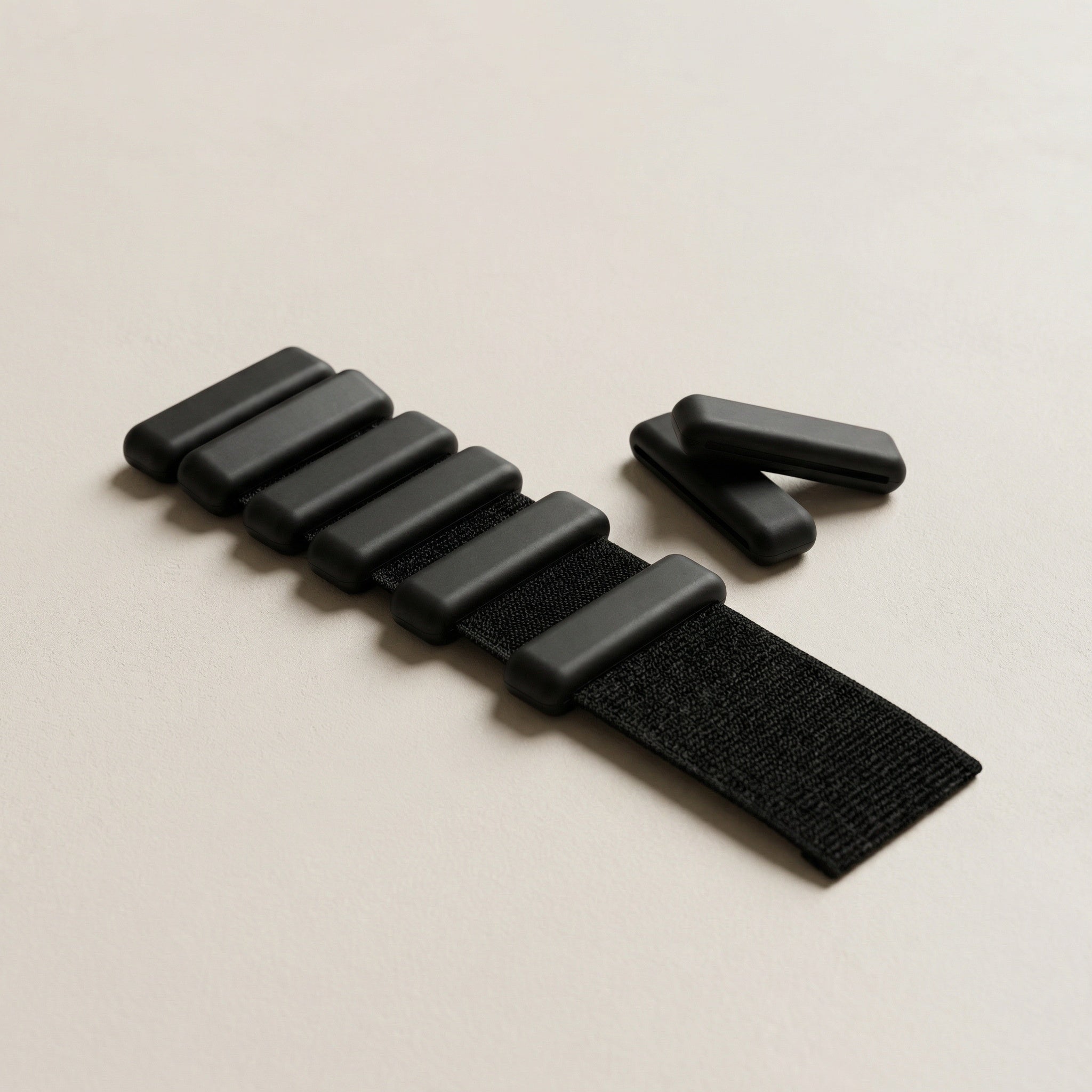 svarta pilates handledsvikter liggandes på beige bakgrund