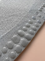 Närbild på undersidan av en grå strumpa för pilates där man ser att strumpan har grepp