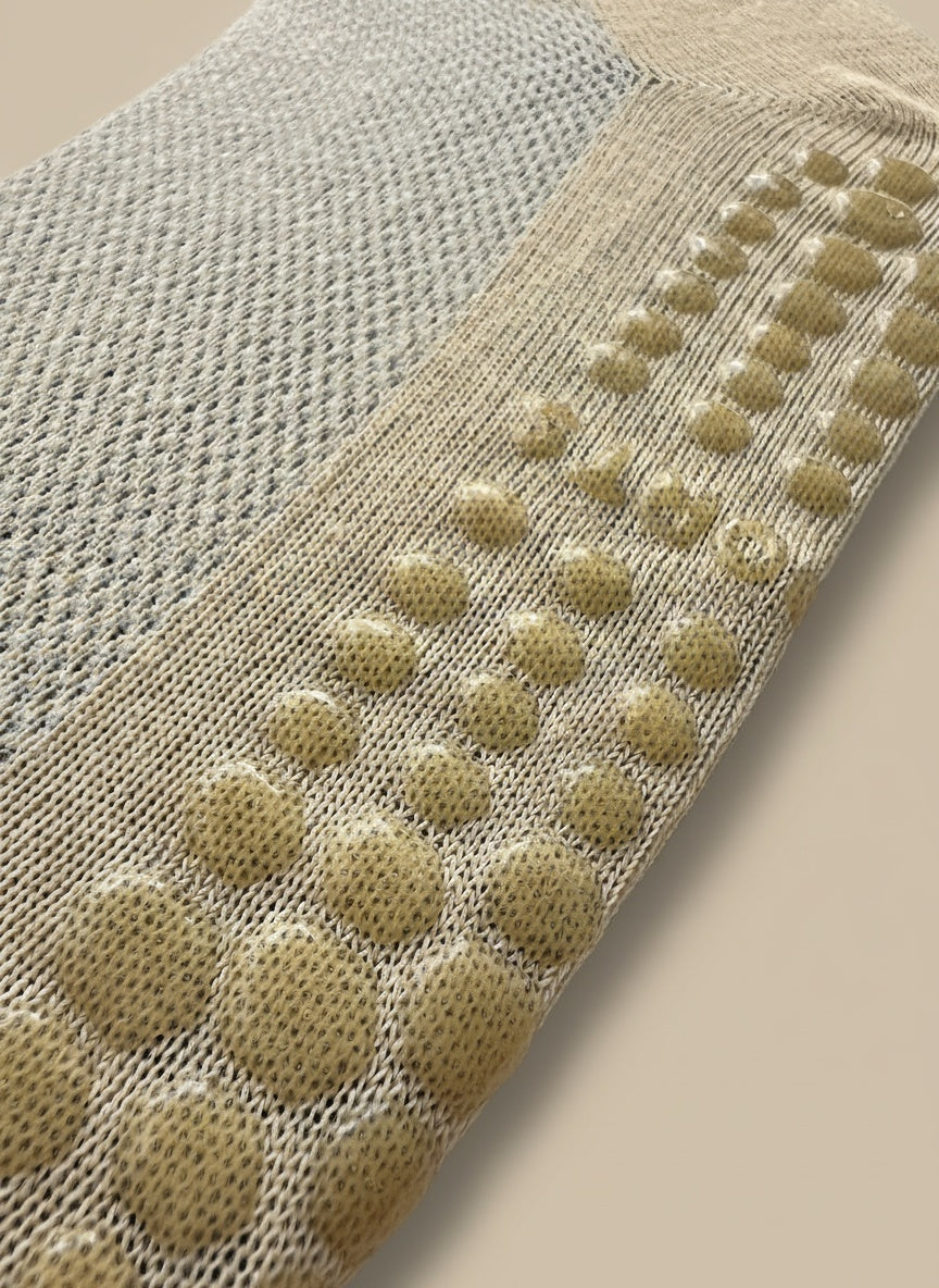 Närbild på undersidan av en orange pilates strumpa för kvinnor med silikon för grepp