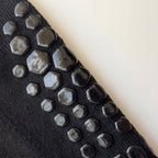 Närbild av anti halk grepp på pilatesstrumpor i svart mot beige bakgrund