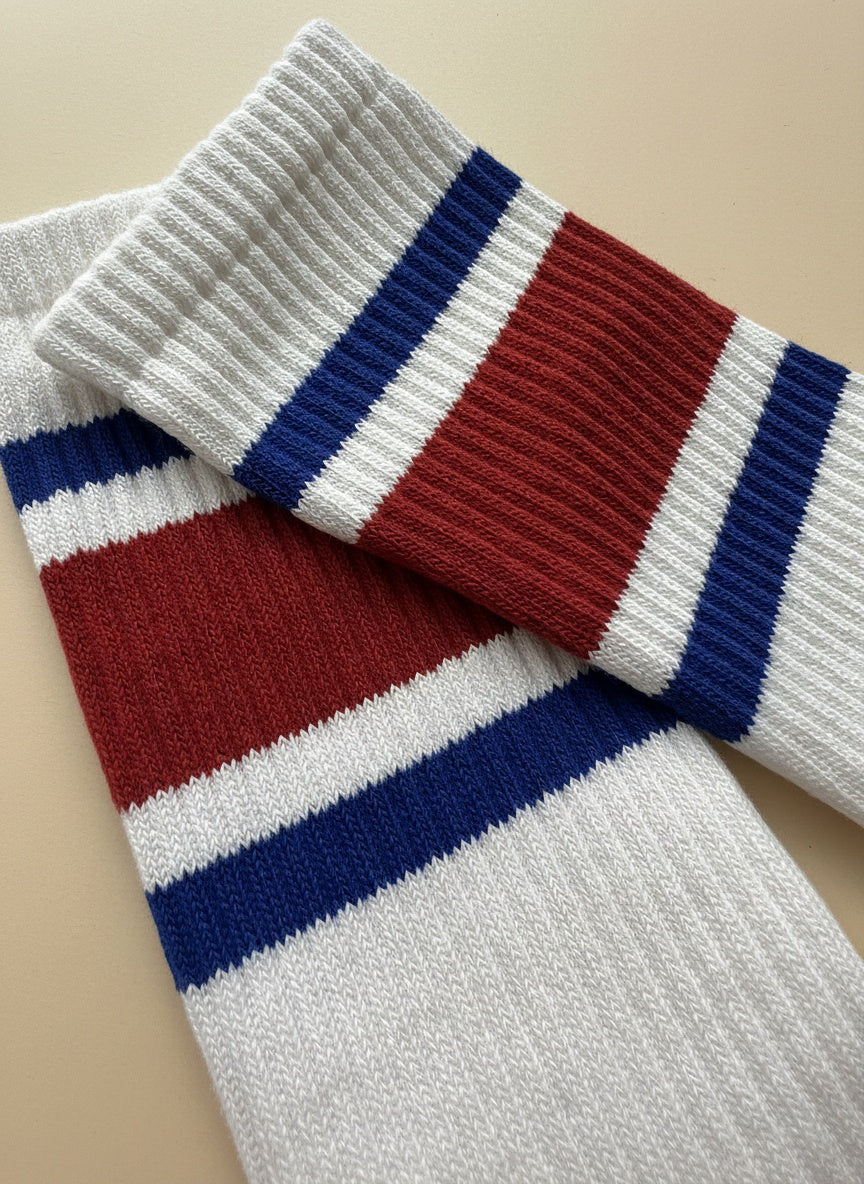 nära bild tagen på ett par vit röd blå pilates strumpor på en beige bakgrund