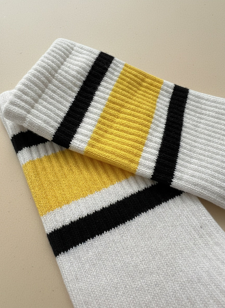 Close up bild på toppen av ett par pilatesstrumpor för kvinnor ligger på ett beige golv