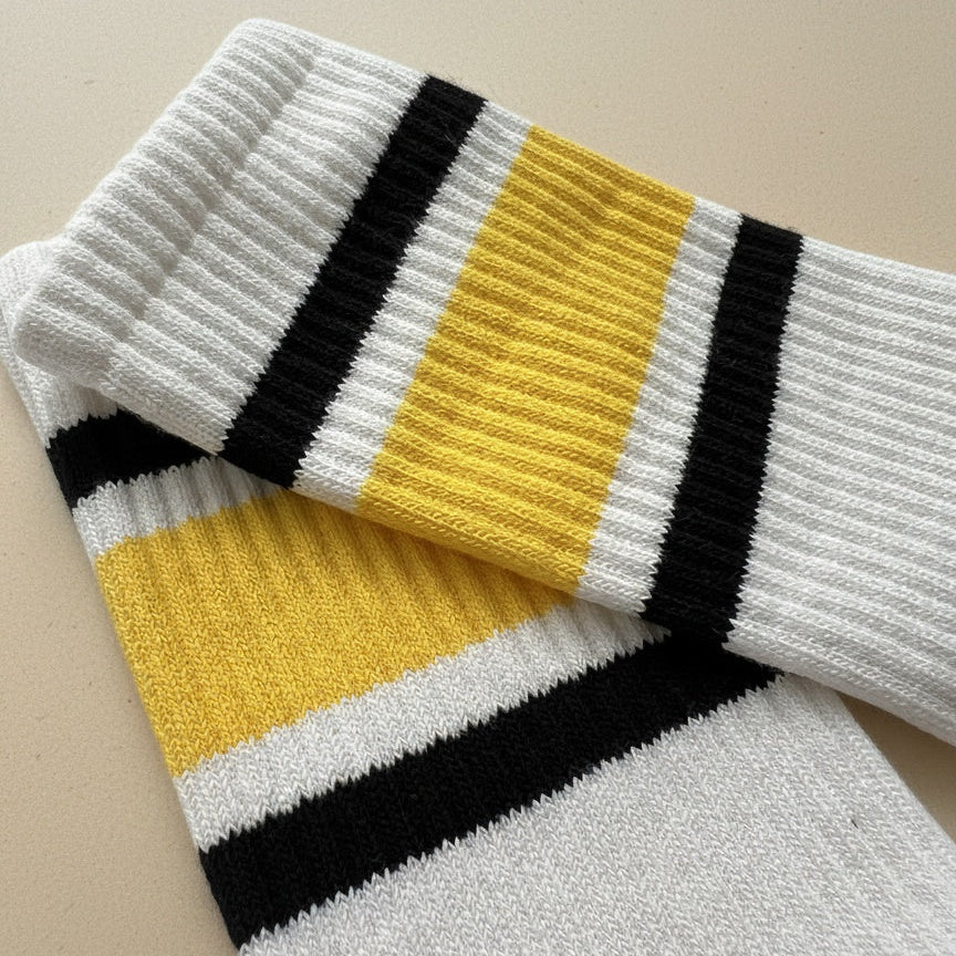 Close up bild på toppen av ett par pilatesstrumpor för kvinnor ligger på ett beige golv