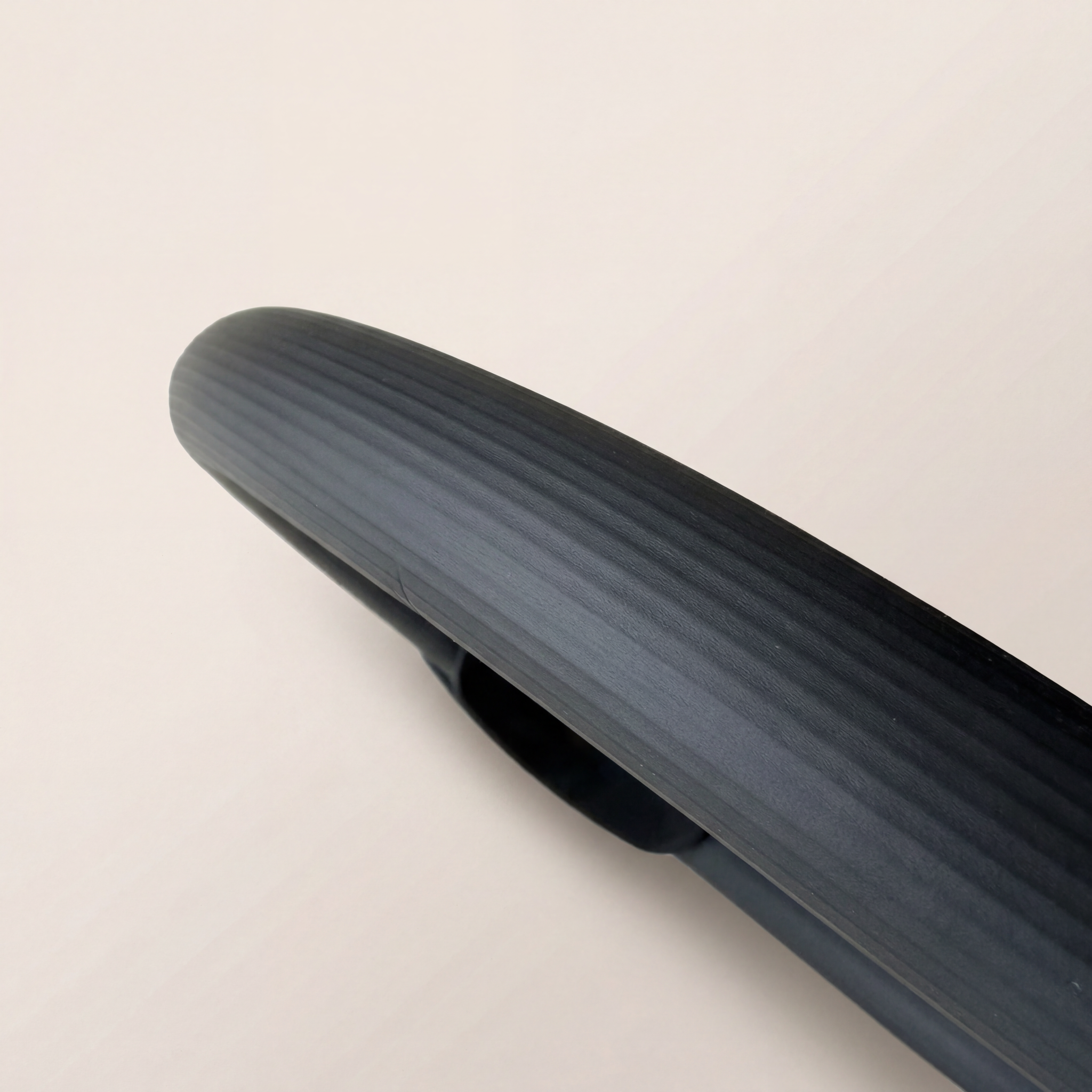 svart träningsredskap för pilates nrbild mot beige yta