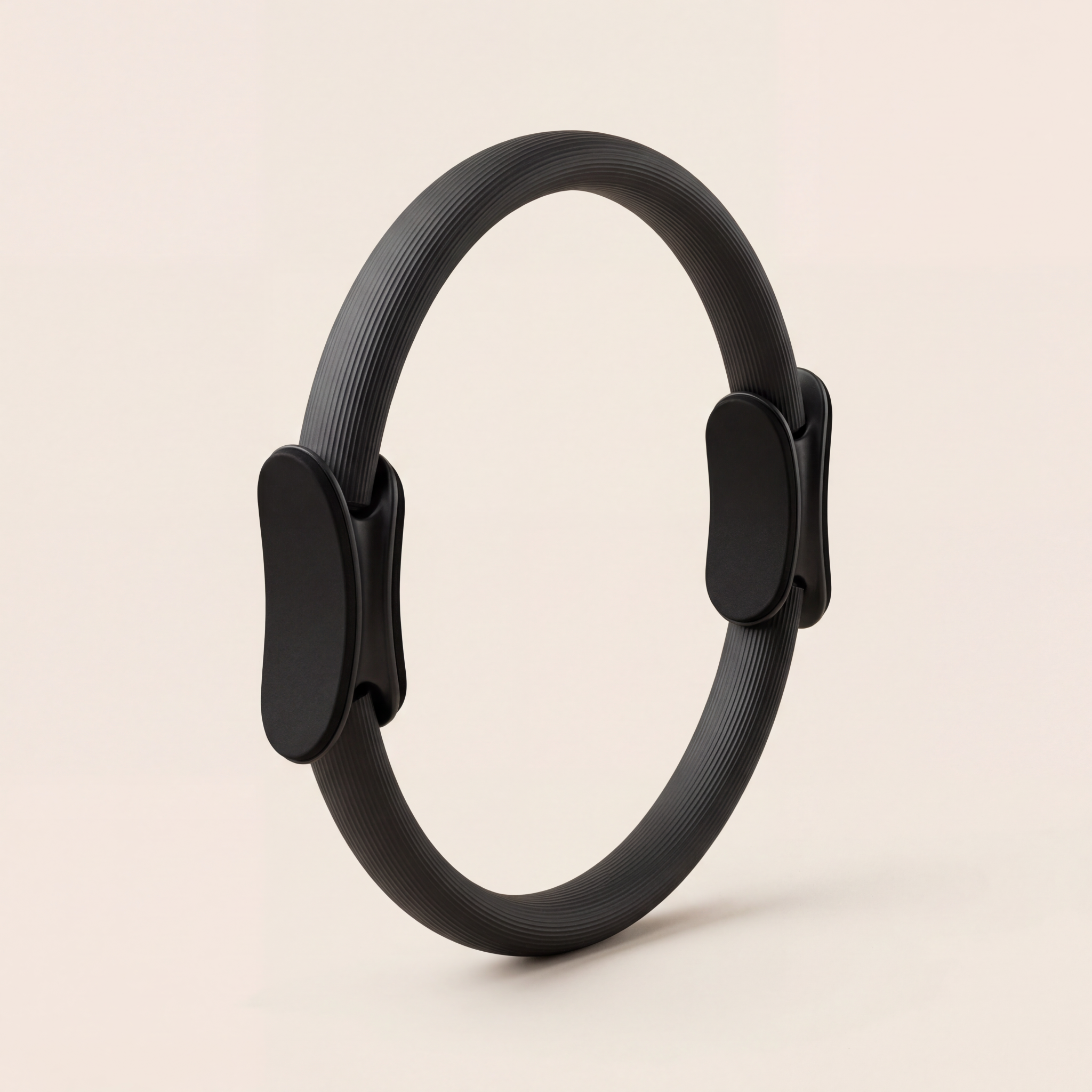 svart pilatesring träningsredskap hemma på bege bakgrund