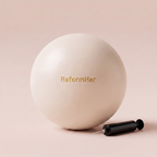 beige bilatesboll med svart pump liggandes mot beige studiobakgrund