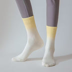 Kvinna med pilates strumpor för yoga på vitt golv i täningsstudio