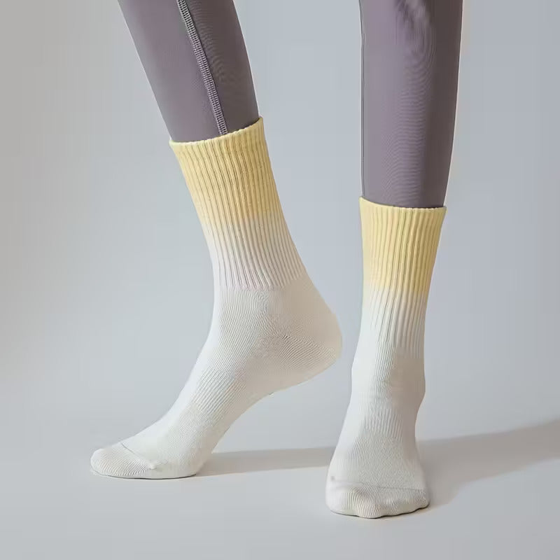 Kvinna med pilates strumpor för yoga på vitt golv i täningsstudio