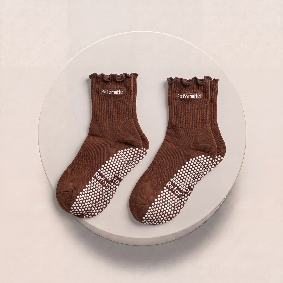 brown and white pilates sticky socks on podium