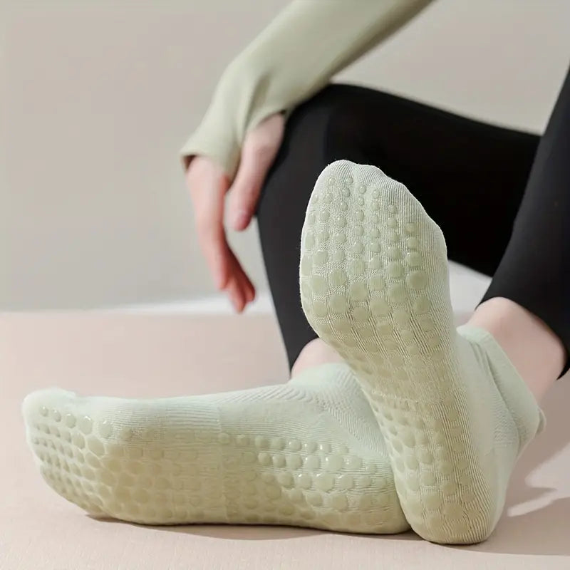 Kvinna fläker upp sin fot och exponerar solikon grepp på sina strumpor för pilates