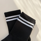 svarta grippy socks liggandes mot vit bakgrund i solen