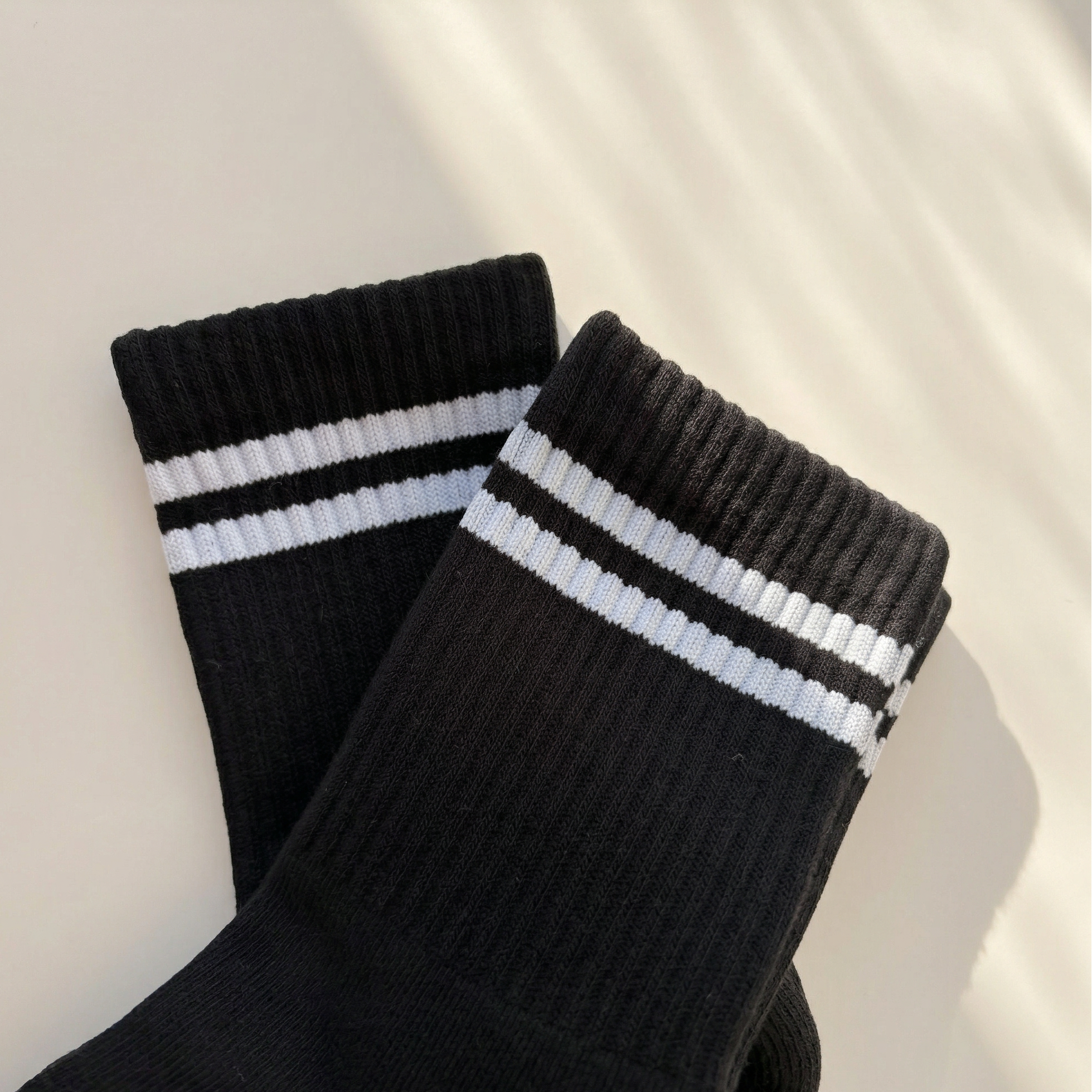 svarta grippy socks liggandes mot vit bakgrund i solen