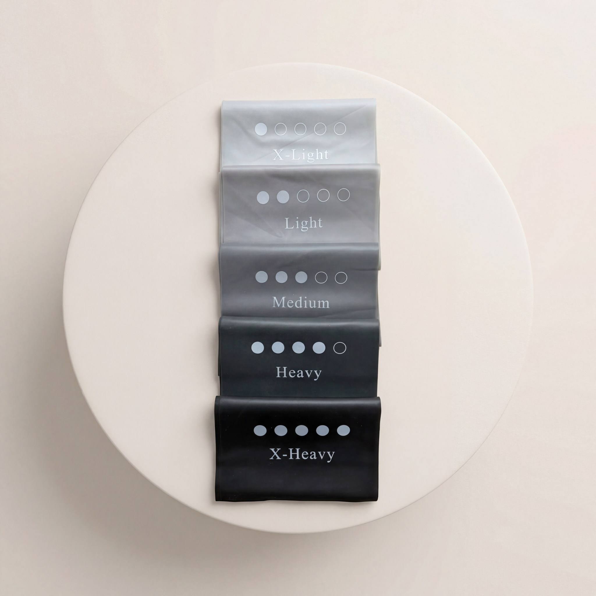 Träningsband för pilates liggandes som gummiband för träning på beige cylinder